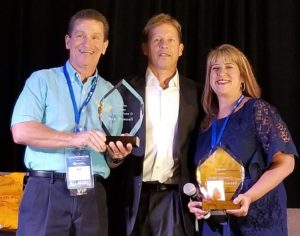 Rob and Claudia accepting their ReMentor Real Estate Investor Hall of Fame trophies in 2018.